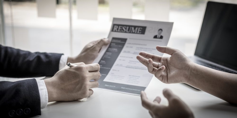 Job candidate presenting a resume to an interviewer during a pre-employment interview.